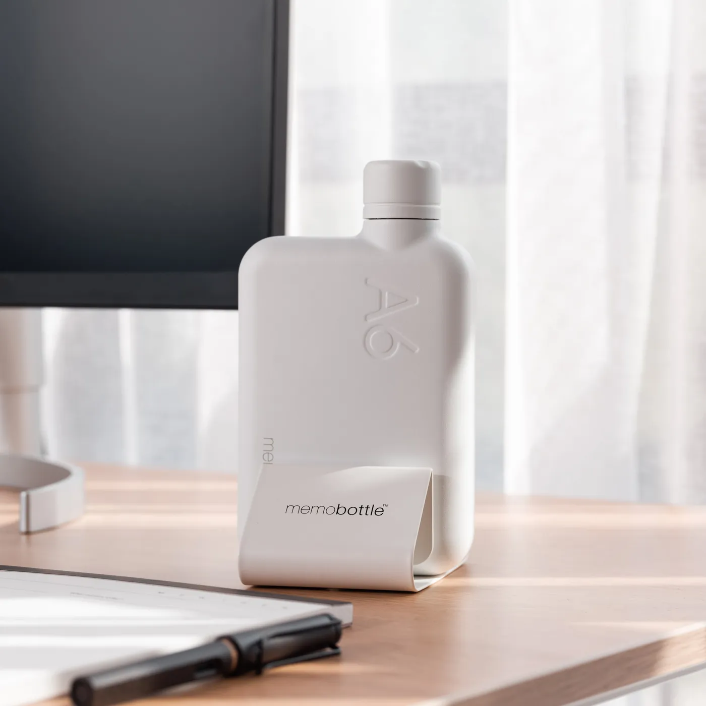 Universal Memobottle Holder in White with a Bottle on the Desk