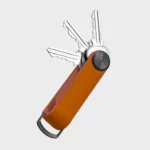 Orbitkey Key Organiser Tracker in Orange, geöffnet mit drei aufgefächerten Schlüsseln und D-Ring