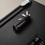 Orbitkey Key Organiser Tracker in Schwarz mit Schlüsseln auf einer schwarzen Schreibtischunterlage neben der Tastatur