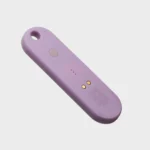 Orbitkey Universal Tracker in Lila, Rückseite schräg mit Taste und magnetischem Ladeanschluss