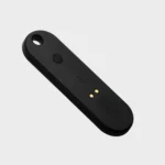 Orbitkey Universal Tracker in Schwarz, Rückseite schräg mit Taste und magnetischem Ladeanschluss