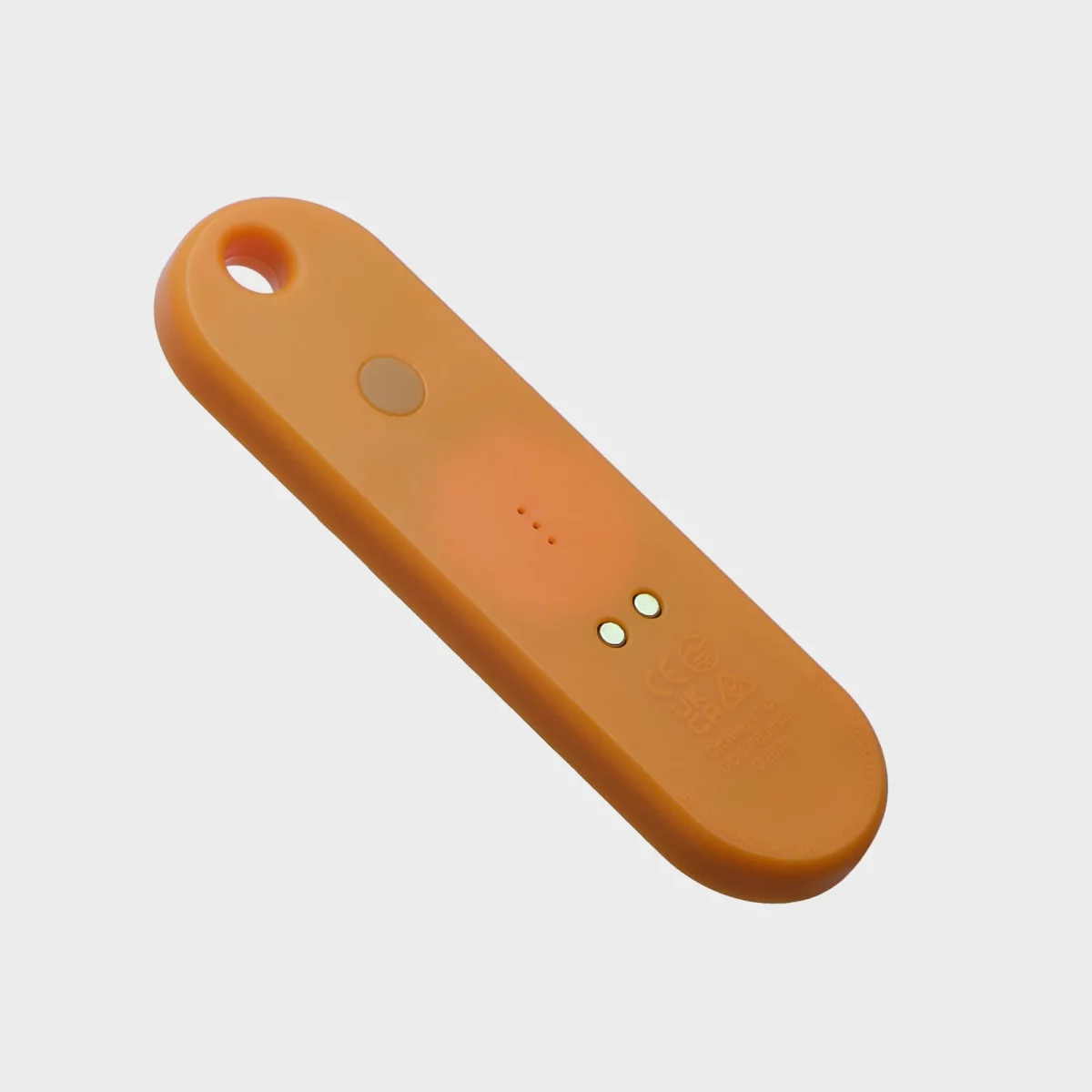 Orbitkey Universal Tracker in Tangerine, Rückseite schräg mit Taste und magnetischem Ladeanschluss