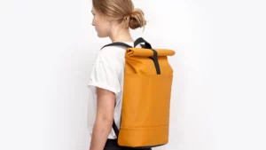 Frau trägt den Ucon Acrobatics Hajo Rolltop-Rucksack in Gelb auf dem Rücken