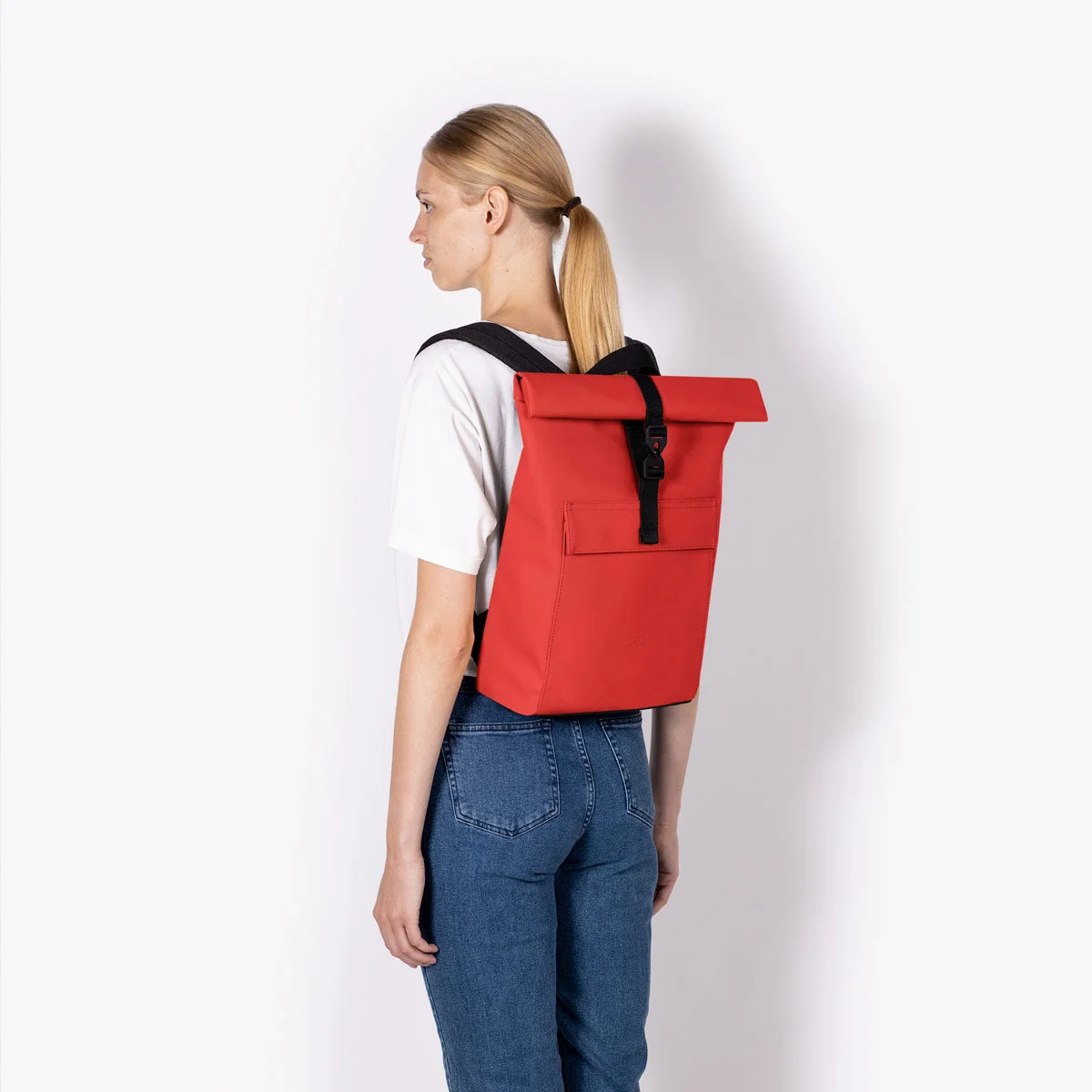 Frau trägt den Ucon Acrobatics Jasper Medium Rucksack in Rot