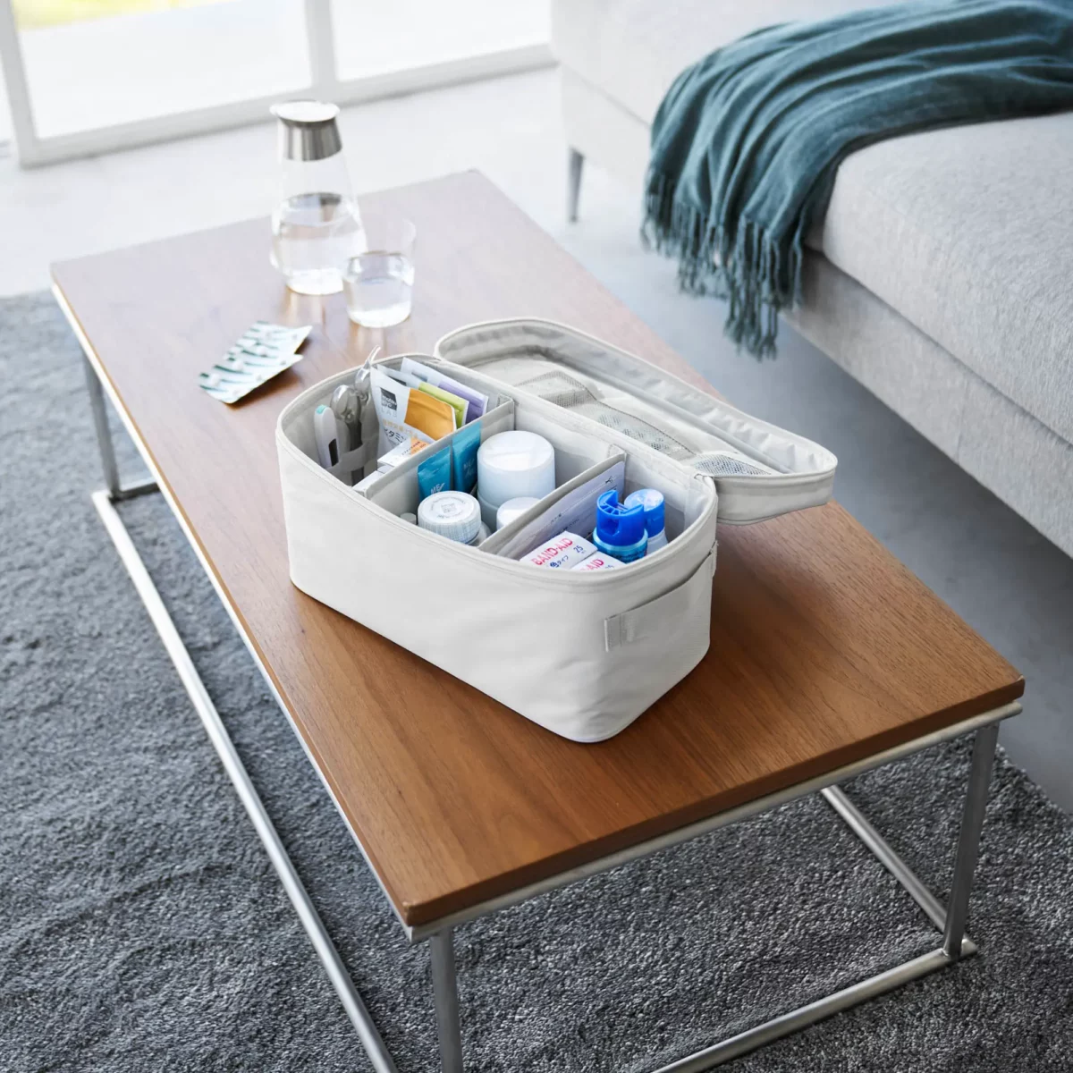 Yamazaki TOWER Storage Bag with Dividers in Gray, open with a first-aid kit on the coffee table