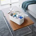 Yamazaki TOWER Storage Bag with Dividers in Gray, open with a first-aid kit on the coffee table