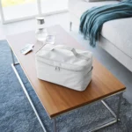 Yamazaki TOWER Storage Bag with Dividers in Gray, sitting on the coffee table in the living room