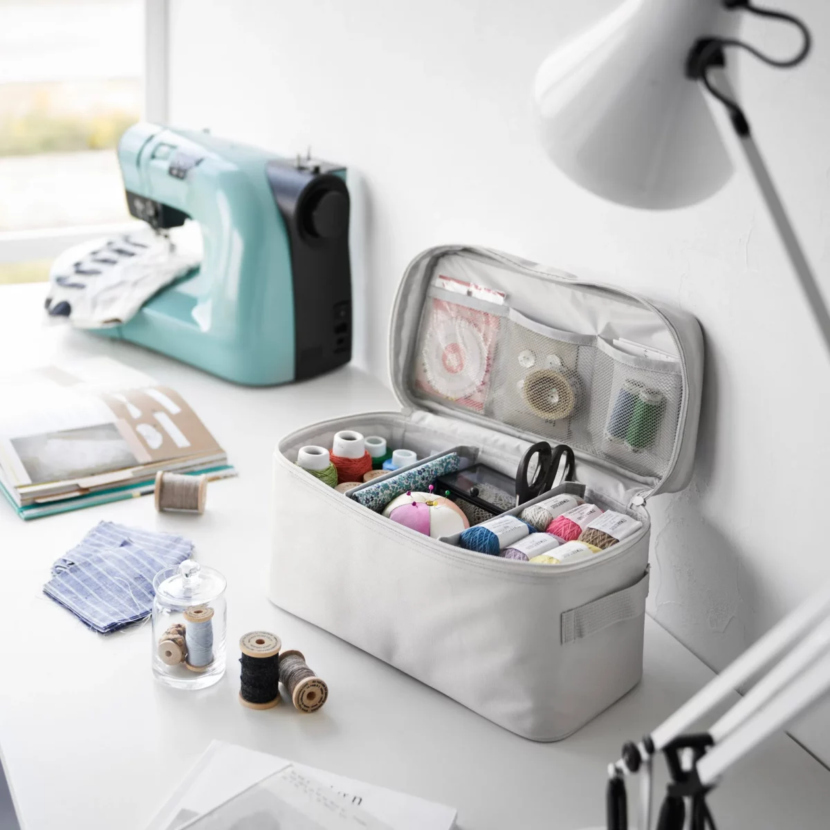 Yamazaki TOWER Storage Bag with Dividers in Gray, with a sewing kit next to the sewing machine