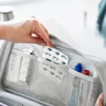 Yamazaki TOWER Storage Pouch with Dividers in Gray; the user can remove pills from the mesh pocket in the lid