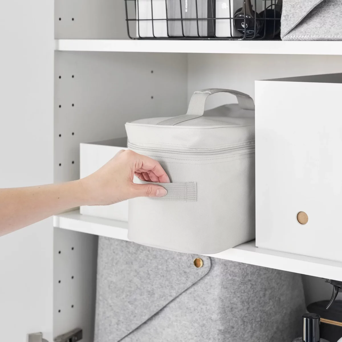 Yamazaki TOWER Storage Bag with Dividers in Gray, pulled out of the cabinet shelf by the side handle