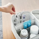 Yamazaki TOWER Storage Bag with Dividers in Gray; a person is inserting a thermometer into the divider compartment