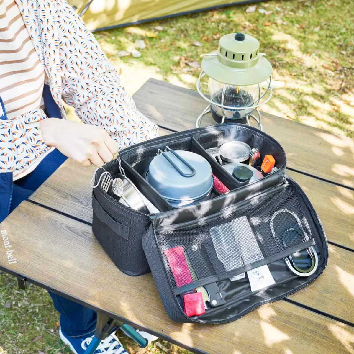 Yamazaki TOWER Storage Bag with Dividers in Black, laid out on the camping table with dishes and cables