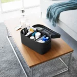 Yamazaki TOWER Storage Bag with Dividers in Black, open on the coffee table with a first-aid kit