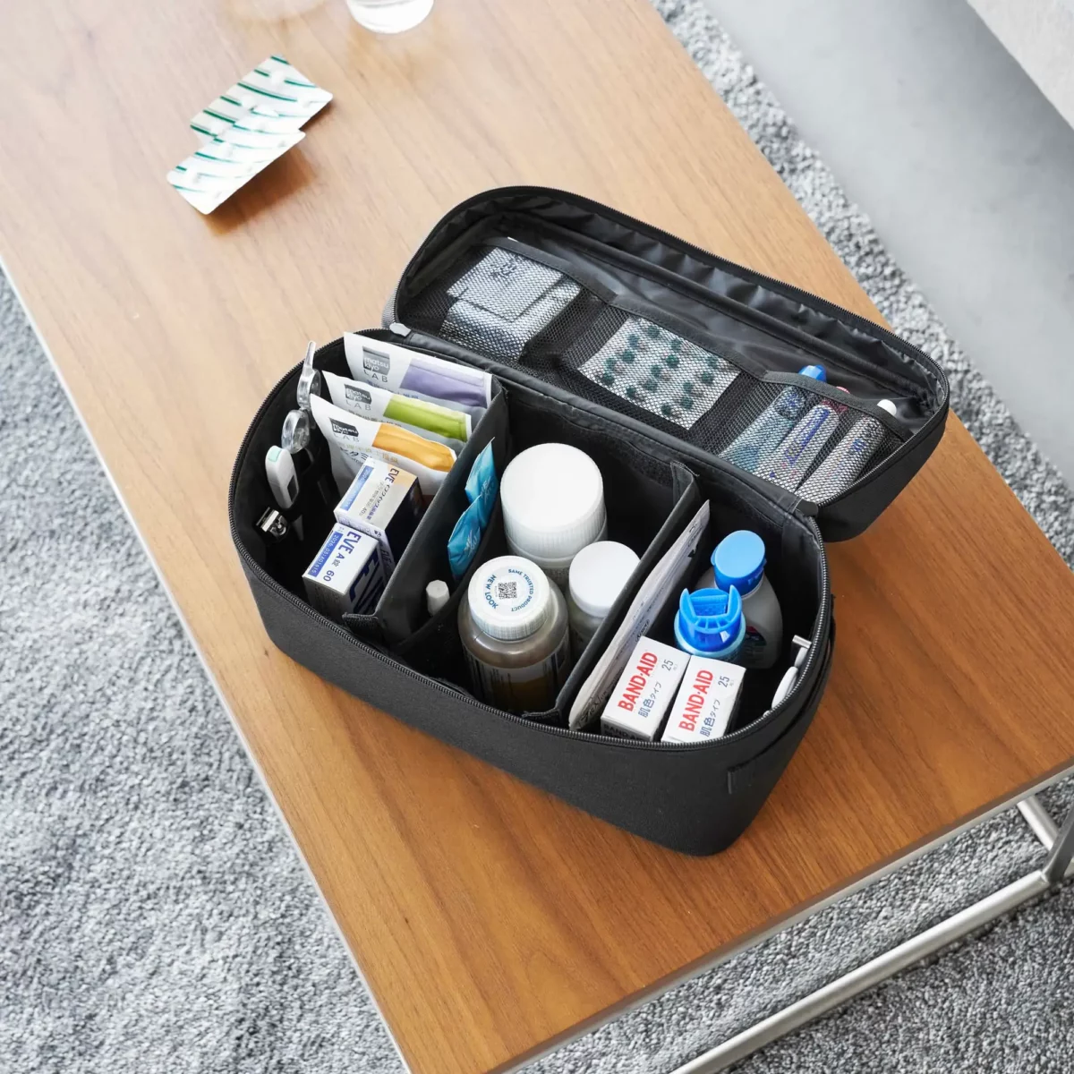 Yamazaki TOWER Storage Bag with Dividers in Black, shown from above with medications in three compartments
