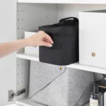 Yamazaki TOWER Storage Bag with Dividers in Black; it is pulled out of the cabinet shelf by the side handle