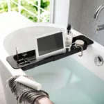 Porte-objets de baignoire Yamazaki TOWER extensible, noir ; vu d'en haut, avec une tablette, une brosse à dents et du savon