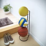 Yamazaki FRAME Ball Stand in Black, with three balls in the entryway next to the shoes