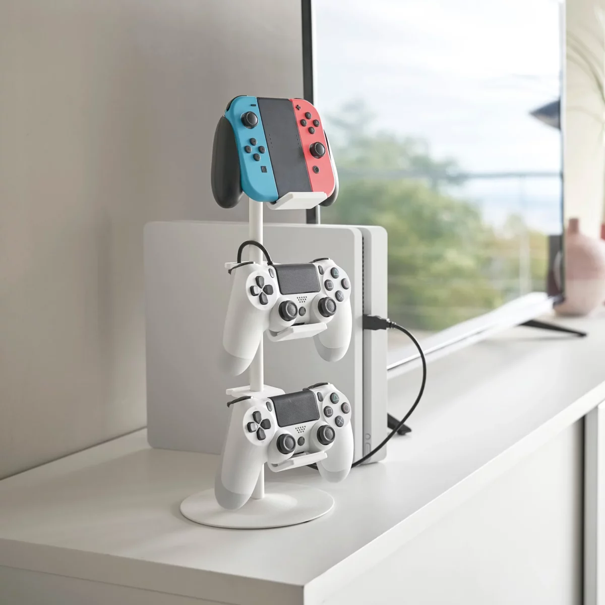 Yamazaki SMART 3-Tier Controller Stand in White, next to the console with three controllers