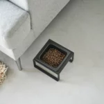 Yamazaki TOWER Food Bowl, single, with stand in black, shown from above next to the sofa with food in the bowl
