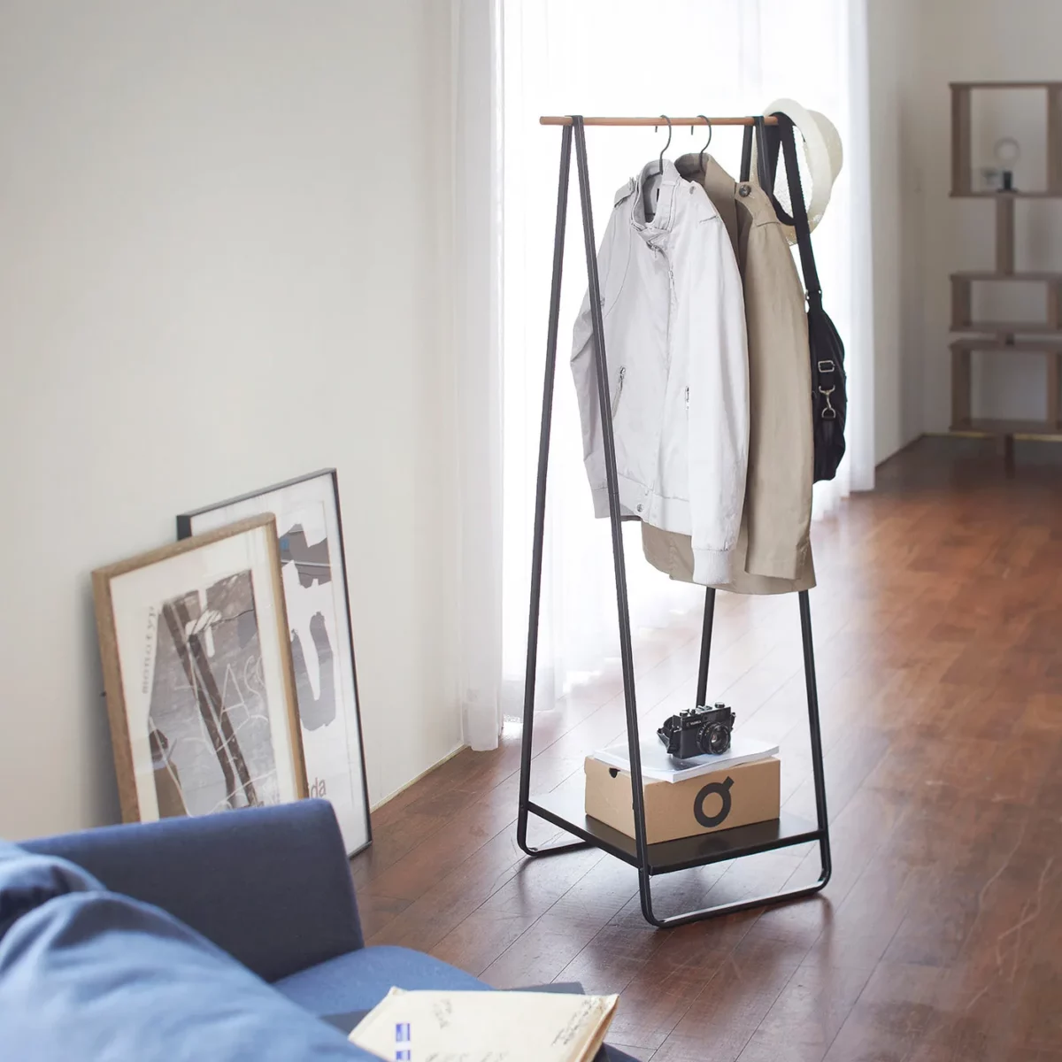 Yamazaki Garderobe TOWER mit Ablage in Schwarz, im Wohnzimmer mit Hemden und Karton auf der Ablage