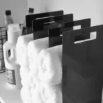 Yamazaki TOWER Towel Storage, 2-Piece Set in Black; close-up of the steel sides with handle holes between the towels