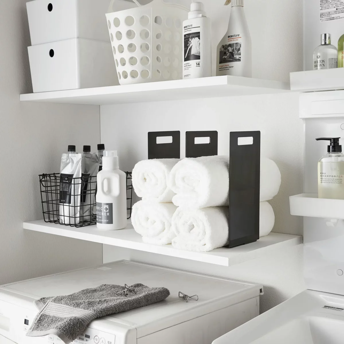 Yamazaki TOWER Towel Storage, 2-Piece Set in Black, showing two rows of rolled towels on the shelf from the front