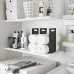 Yamazaki TOWER Towel Storage, 2-Piece Set in Black, showing two rows of rolled towels on the shelf from the front
