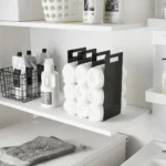 Yamazaki TOWER Towel Storage, 2-Piece Set in Black, with rolled towels on the laundry room shelf