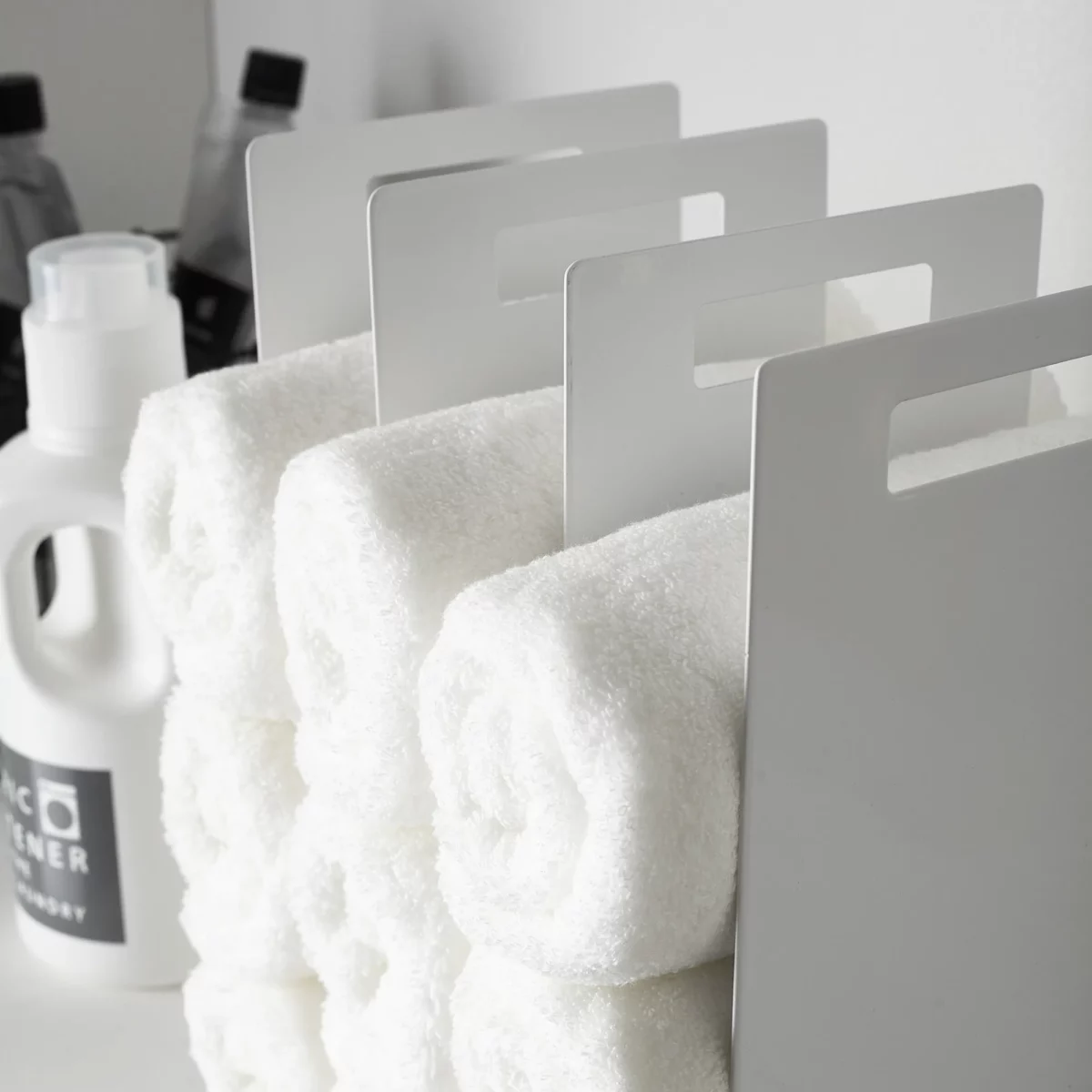 Yamazaki TOWER Towel Storage, Set of 2 in White; close-up of the steel sides with handle holes between the towels