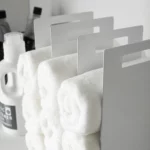 Yamazaki TOWER Towel Storage, Set of 2 in White; close-up of the steel sides with handle holes between the towels