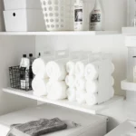 Yamazaki TOWER Towel Storage, 2-Piece Set in White, showing two rows of rolled towels on the shelf from the front