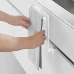 Yamazaki Handtuchhalter TOWER zum Einhängen in Weiss, Hände hängen ein Geschirrtuch über den Bügel