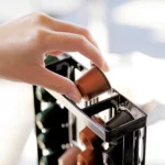Yamazaki Kaffeekapselhalter TOWER in Schwarz, Hand füllt eine Kapsel oben in eine Säule