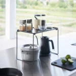 Yamazaki Klappregal TOWER stapelbar L in Schwarz, auf der Arbeitsfläche mit Gläsern über Wasserkocher und Topf