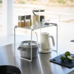 Yamazaki Klappregal TOWER stapelbar L in Weiss, auf der Arbeitsfläche mit Gläsern über Wasserkocher und Topf