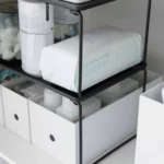 Yamazaki Klappregal TOWER stapelbar M in Schwarz, Nahaufnahme mit Wattepads über Ordnerboxen