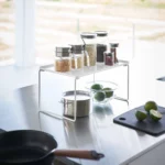 Yamazaki Klappregal TOWER stapelbar M in Weiss, auf der Arbeitsfläche mit Gläsern über einem Topf