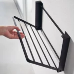 Yamazaki TOWER Folding Wall Shelf in Black; the shelf folds down from the wall by hand