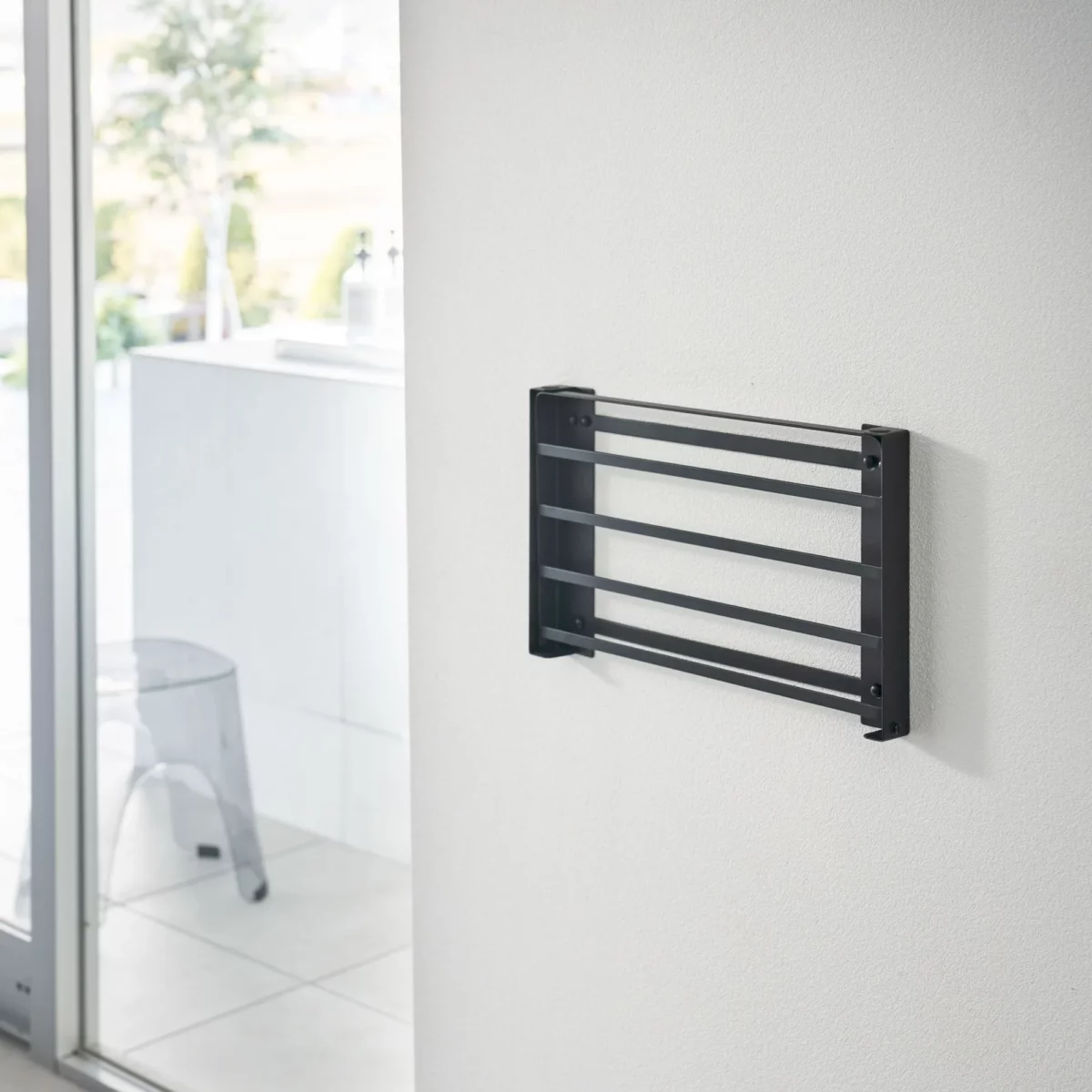 Yamazaki TOWER Folding Wall Shelf in Black; when folded, it lies flat against the bathroom wall