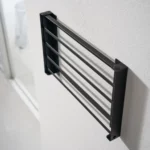 Yamazaki TOWER Folding Wall Shelf in Black, shown folded and mounted on the wall (side view)