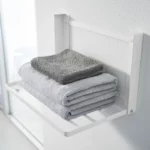 Yamazaki TOWER Folding Wall Shelf in White, close-up with towels on the steel struts