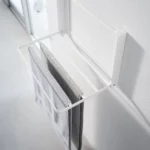 Yamazaki TOWER Folding Wall Shelf in White; a towel hangs over the supports to dry