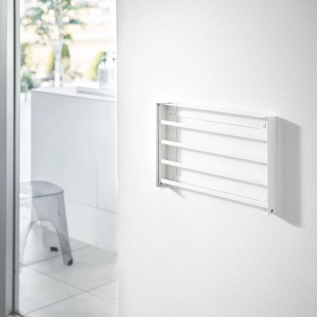 Yamazaki TOWER Folding Wall Shelf in White; when folded, it lies flat against the bathroom wall