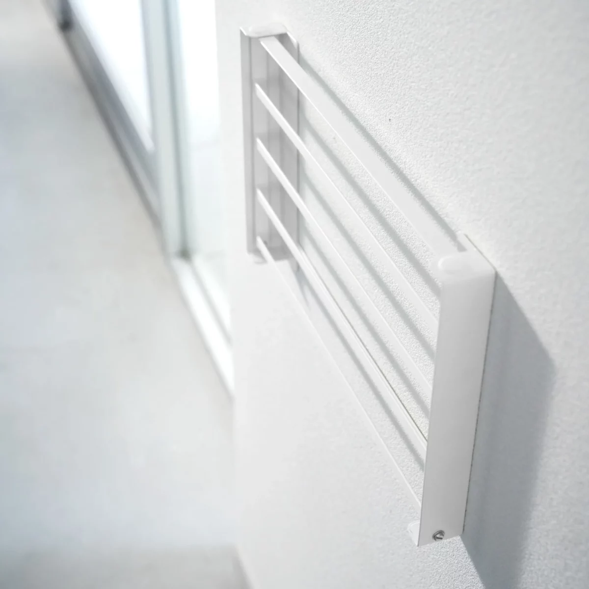 Yamazaki TOWER Folding Wall Shelf in White, shown folded and mounted on the wall (side view)