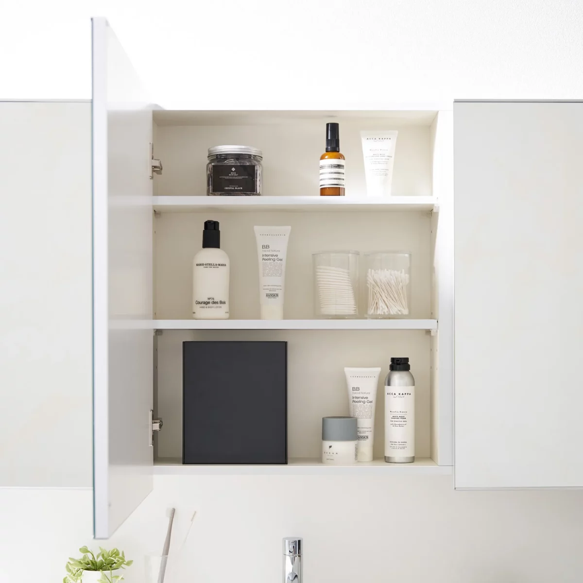 Boîte à crochets adhésifs Yamazaki TOWER avec couvercle, de couleur noire, dans l'armoire à miroir, entre les produits de soin