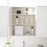 Boîte à crochets adhésifs Yamazaki TOWER avec couvercle, de couleur blanche, dans l'armoire de toilette, entre les produits de soin