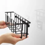 Yamazaki TOWER Film Hook multi-use basket L in black, hands placing the basket onto the adhesive hook