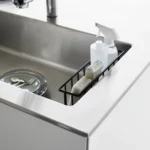 Yamazaki TOWER Film Hook multi-use basket L in black, top view inside the sink with bottles and a sponge