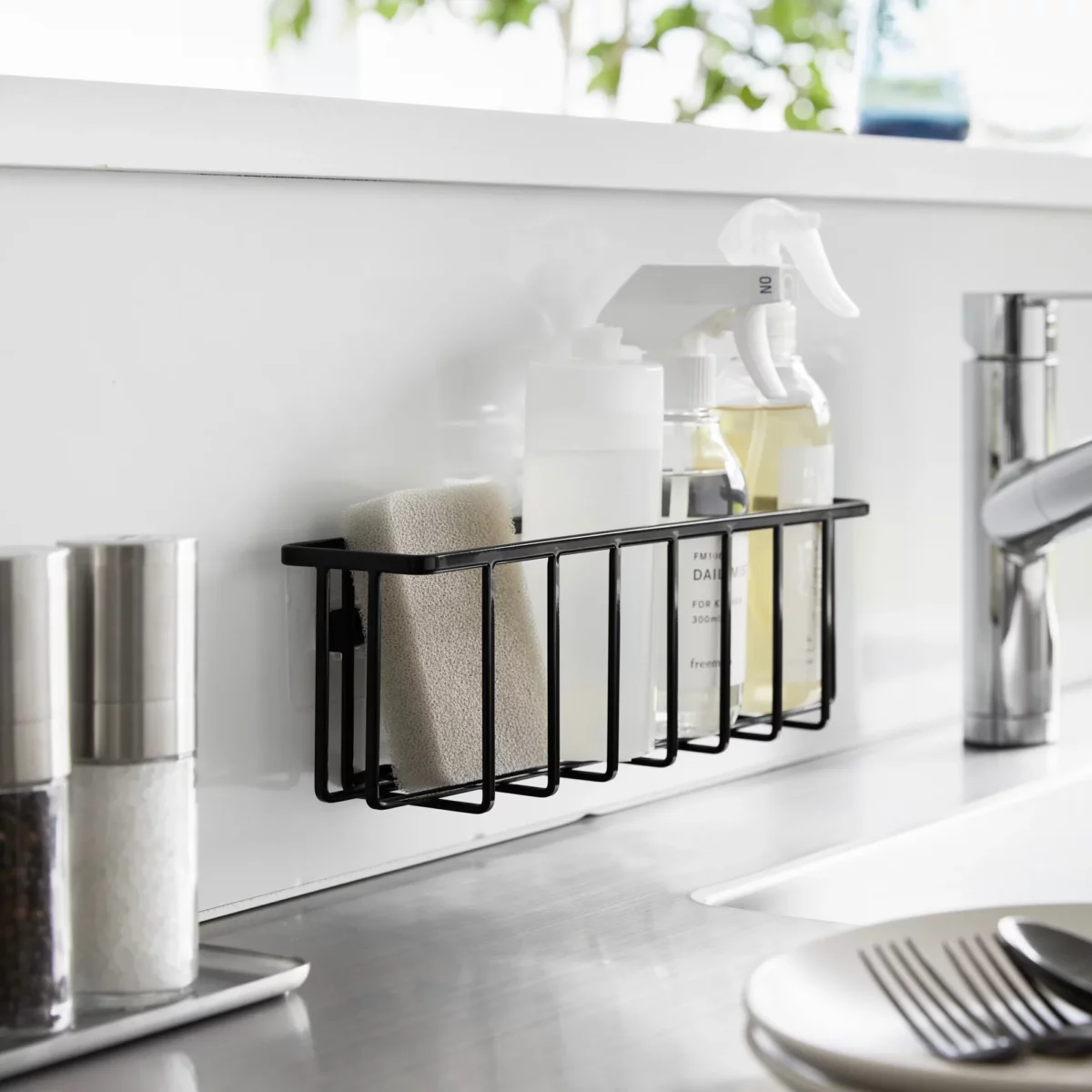 Yamazaki TOWER Film Hook multi-use basket L in black, on the back wall of the sink with bottles and a sponge