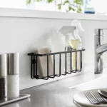 Yamazaki TOWER Film Hook multi-use basket L in black, on the back wall of the sink with bottles and a sponge